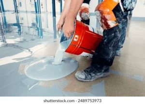 Painters pouring gray coating on an industrial floor in Richmond, VA