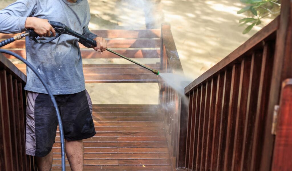 Worker pressure washing a deck in Richmond, VA